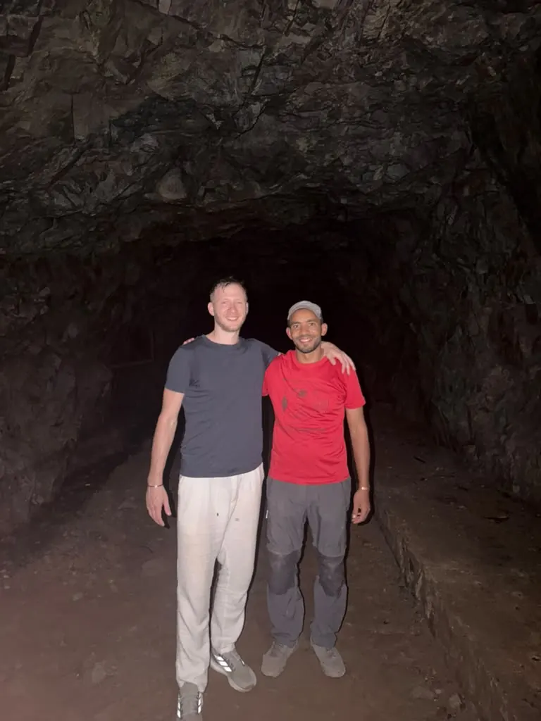 Khalid with a guest inside the cave on the Villages, Caves and Waterfalls hike