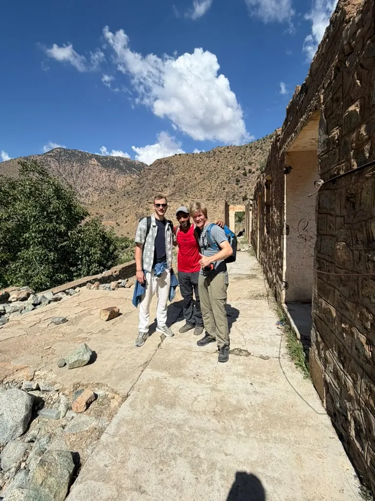 Guests and Khalid beside old earthen ruins