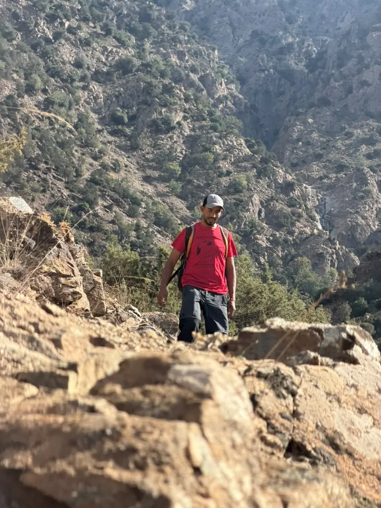 Khalid walking toward the camera across rocks