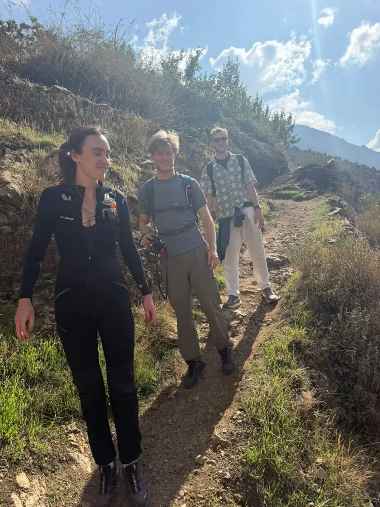 Three hikers on a dirt trail above the Ourika Valley on a day hike from Marrakech