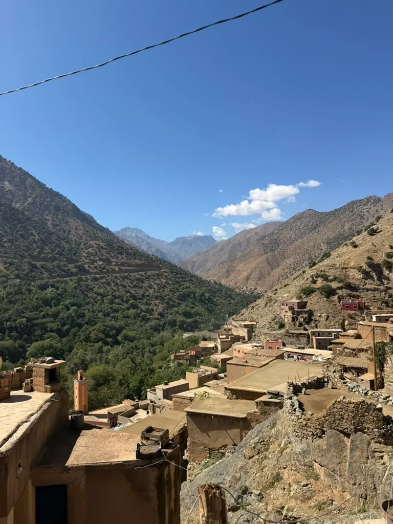 An earthen village above a green valley